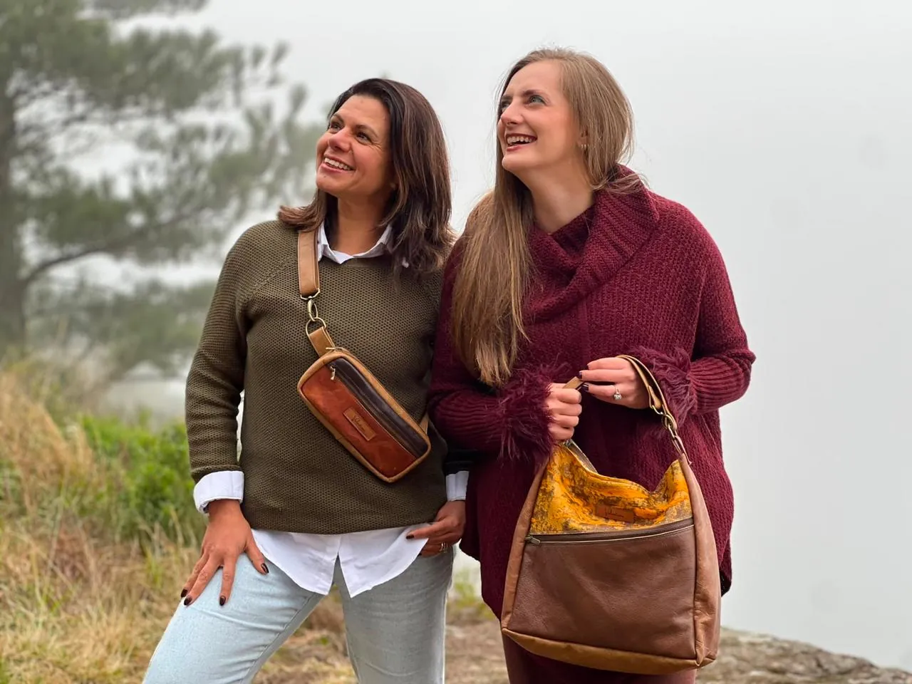 Duas mulheres na serra com bolsas de couro